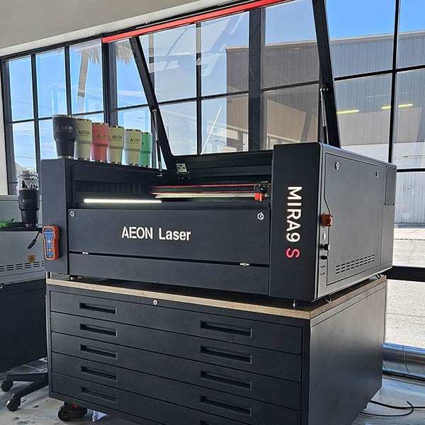Product specialist and person looking at an Aeon laser together in the 78电影网 showroom