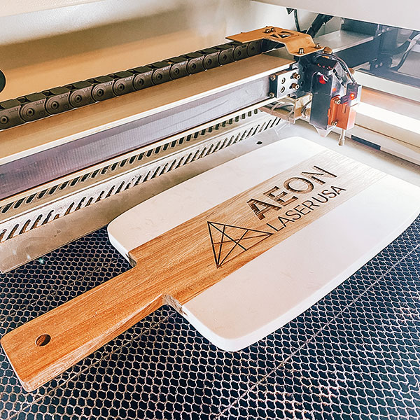 Custom wood and marble cutting board with 奶头又大又白喷奶水av logo engraved on it